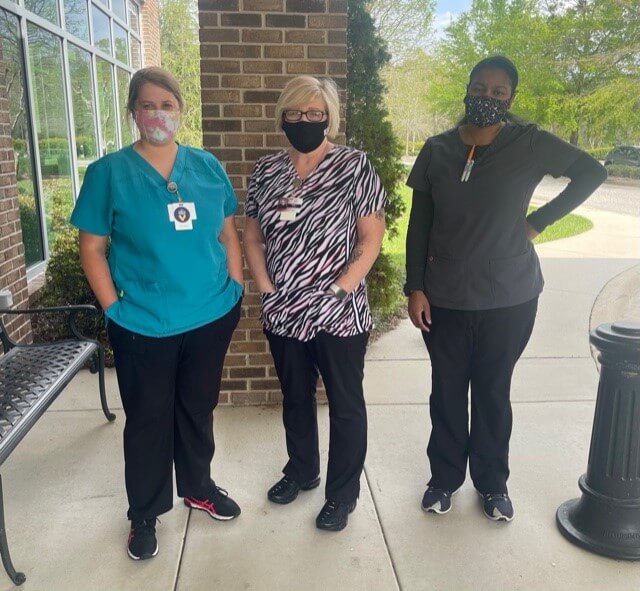 Women standing outside the lab and taking photo